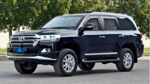 Somalia Armored Vehicle Rental – Bulletproof Cars Hire A sleek, black Toyota Land Cruiser stands confidently outdoors, showcasing its sturdy build and chrome accents under the natural light, with lush green foliage in the background.